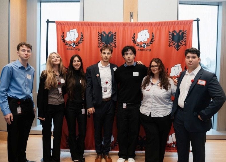 Një grup studentësh duke pozuar përpara sfondit të AANO-s.