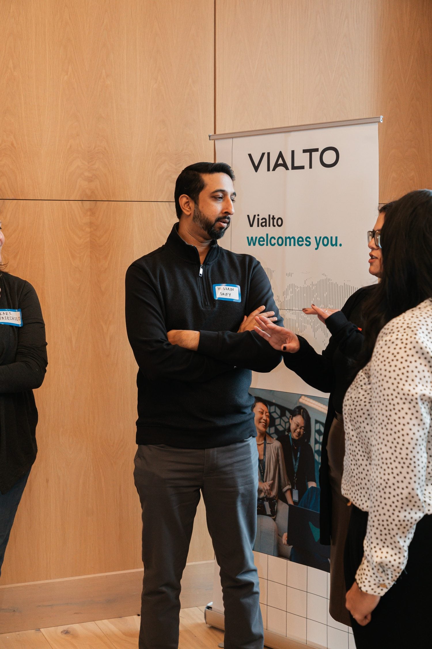 Një përfaqësues i Vialto Partners duke folur me një student pranë banerit të kompanisë.