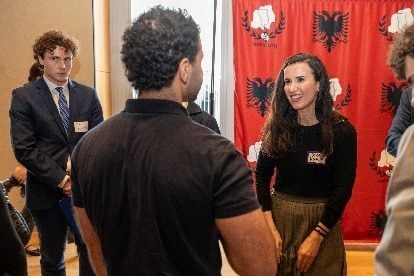 Një profesionist duke folur me studentë përpara sfondit të AANO-s.