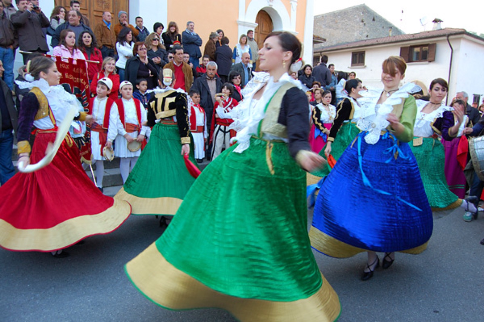 Typical Arbëreshë women's costumes from San Basile in Calabria — embroidered bodices, gold-thread cuffs, and the traditional headpiece.