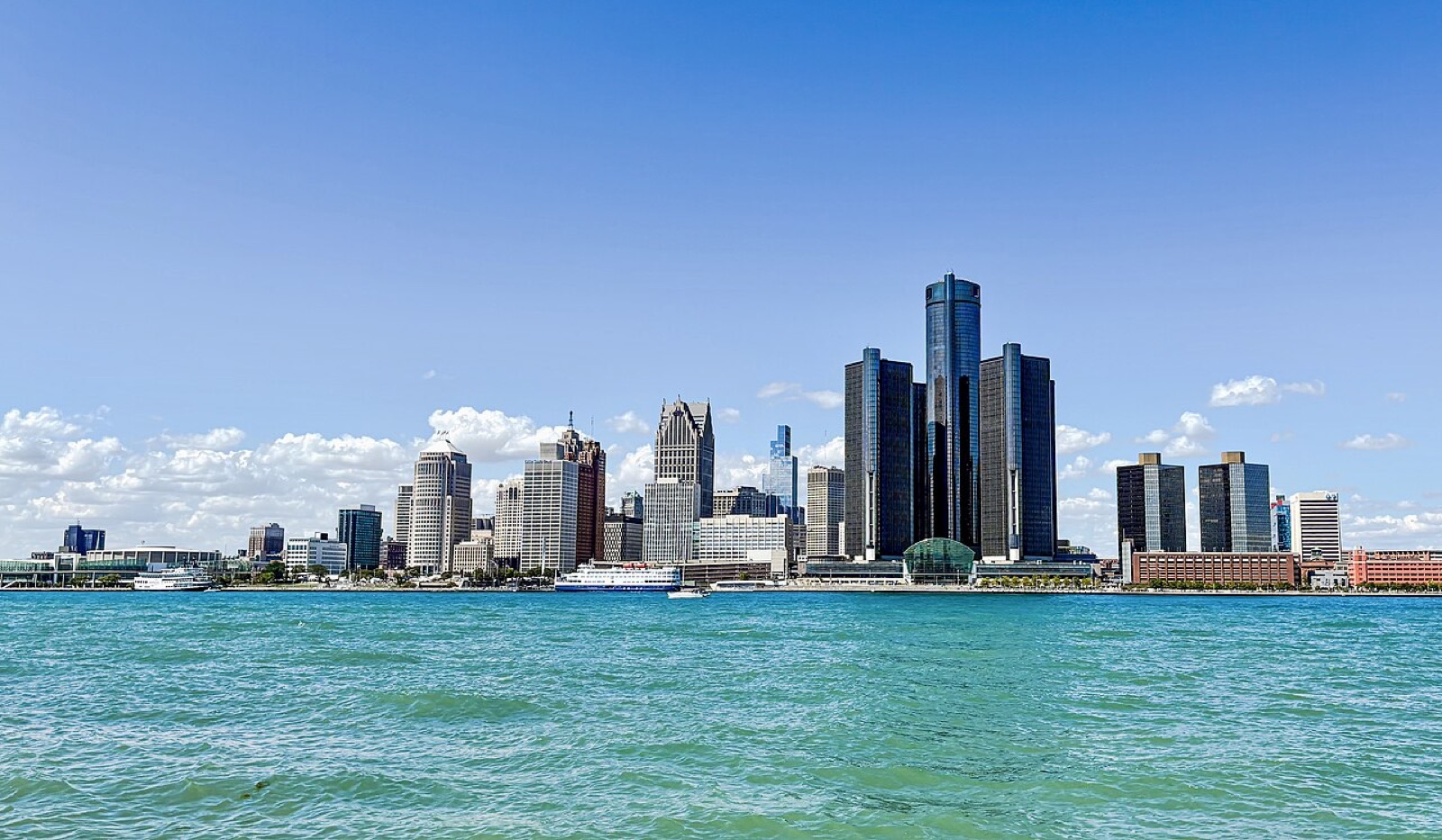 Detroit skyline from across the Detroit River — the metro's outer ring (Sterling Heights, Warren, Hamtramck) holds the largest Albanian community outside New York.