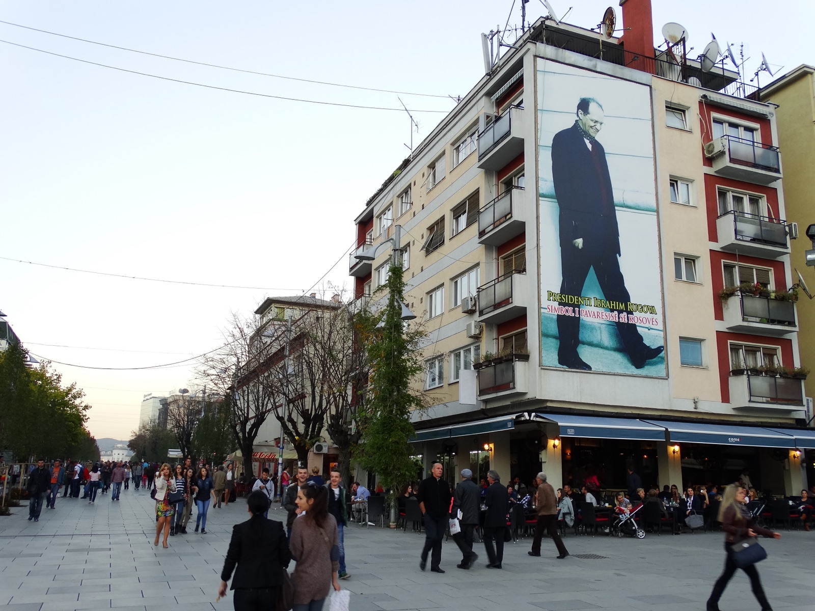 Public portrait of Rugova in Pristina — his trademark silk scarf still recognizable in Kosovo street art.