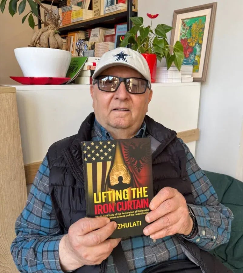 Dr. Ilia Zhulati holding his memoir, Lifting the Iron Curtain
